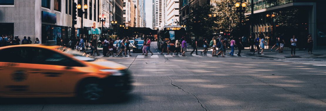 Cab drives by people in crosswalk