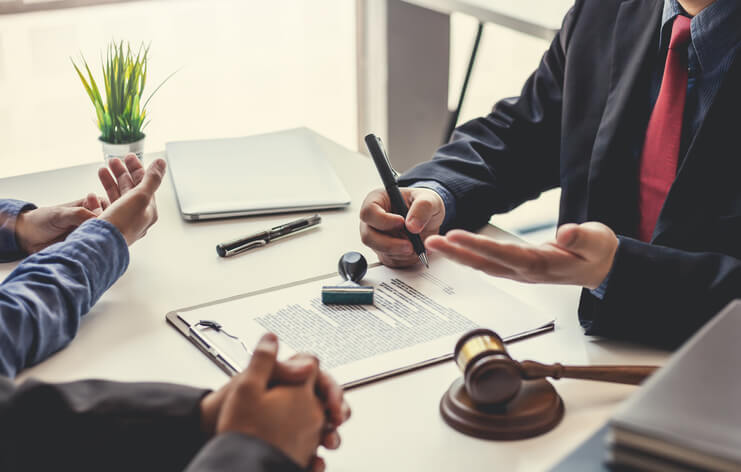 Two male figures looking over and discussing legal documents