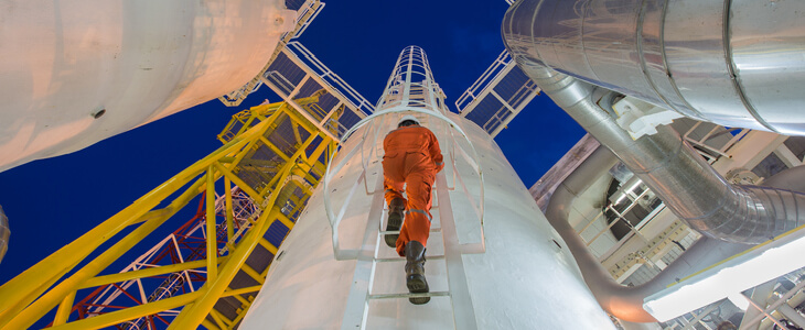 A industrial worker climbing up a silo