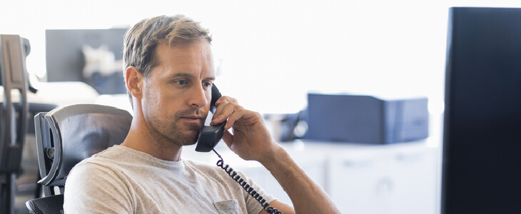 A young businessman talking on the phone after learning about a breach of contract